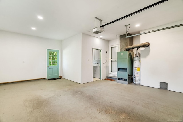 garage featuring water heater, a garage door opener, and heating utilities