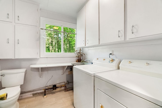 laundry room with washer and clothes dryer and light wood-type flooring