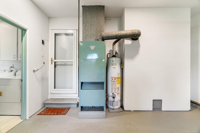 utility room featuring water heater, washing machine and dryer, and heating utilities