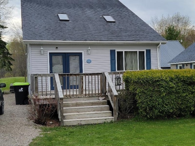 rear view of house with a deck and a yard