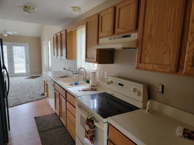 kitchen featuring vaulted ceiling, ceiling fan, electric range, light wood-type flooring, and sink