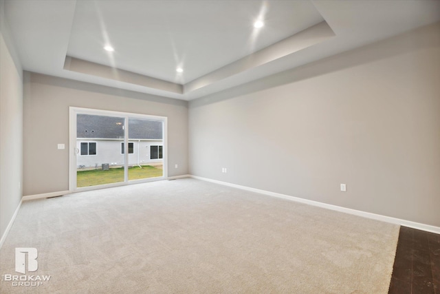 empty room featuring a tray ceiling and hardwood / wood-style flooring