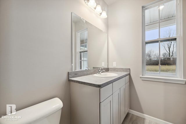 bathroom with hardwood / wood-style floors, vanity, and toilet