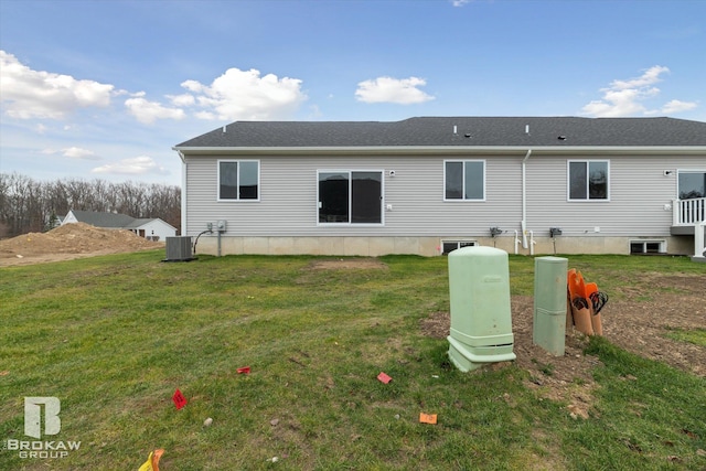 back of house featuring central air condition unit and a yard