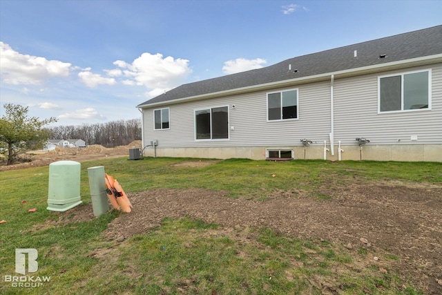 rear view of property featuring central AC unit and a yard