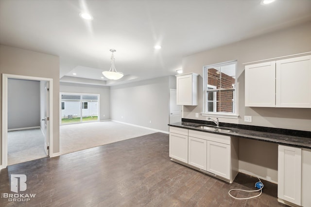 kitchen with pendant lighting, white cabinets, sink, and dark hardwood / wood-style flooring