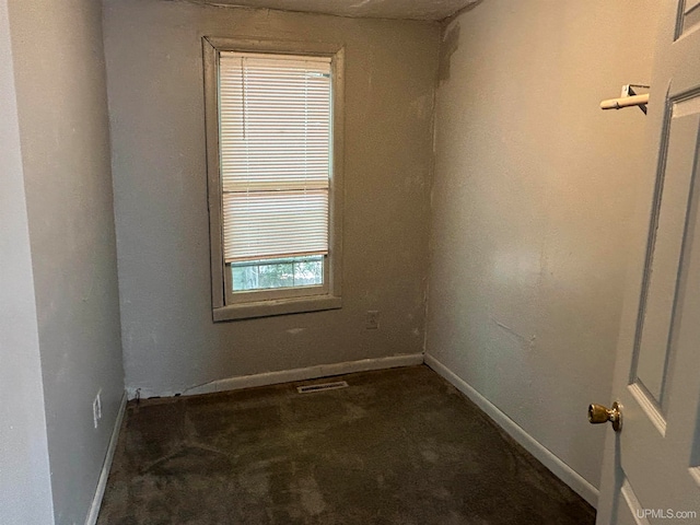 unfurnished room with dark carpet