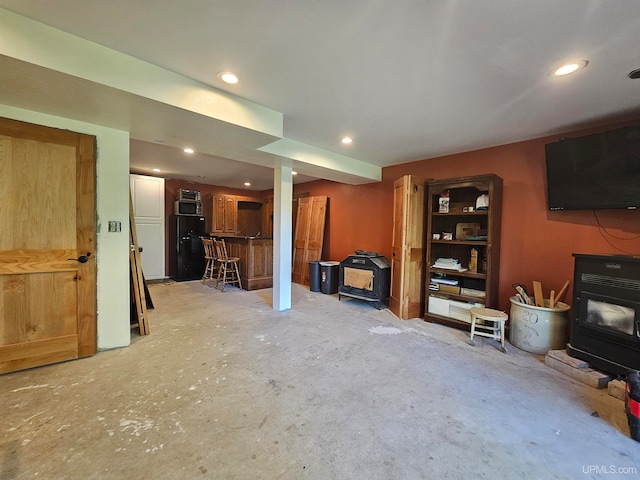 living room featuring concrete flooring and a wood stove