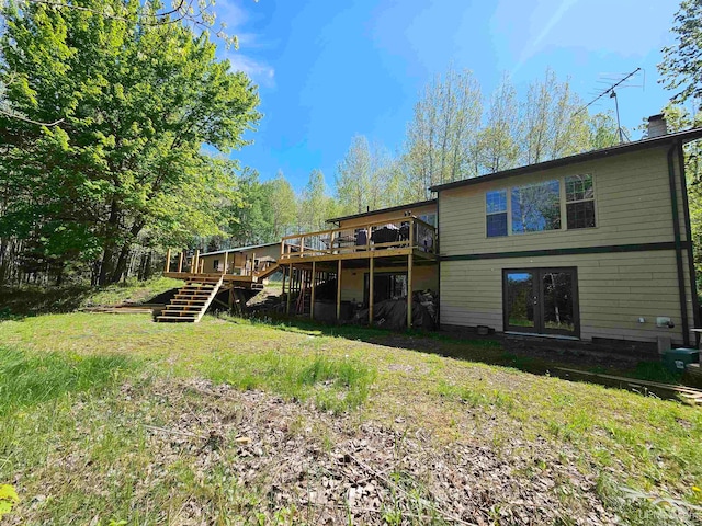 rear view of house featuring a lawn and a wooden deck