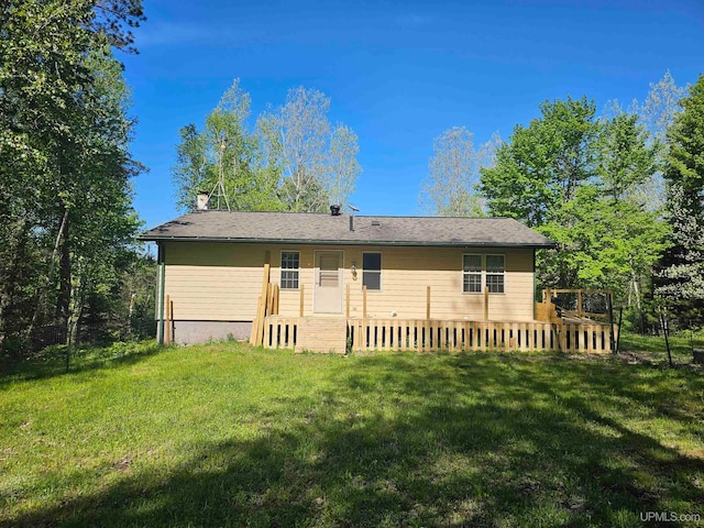 rear view of property featuring a wooden deck and a yard