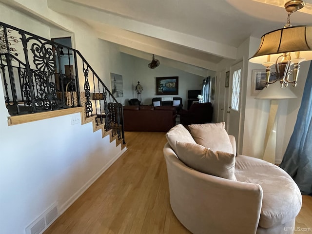 living room featuring vaulted ceiling with beams and wood-type flooring