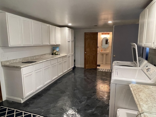 washroom featuring cabinets, washing machine and dryer, and sink