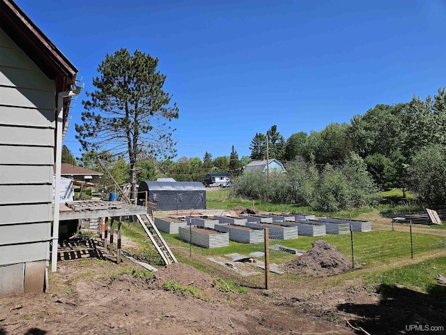 view of yard featuring an outdoor structure and a garden