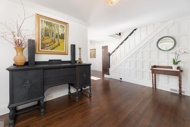 foyer entrance with visible vents, baseboards, ornamental molding, stairway, and dark wood finished floors