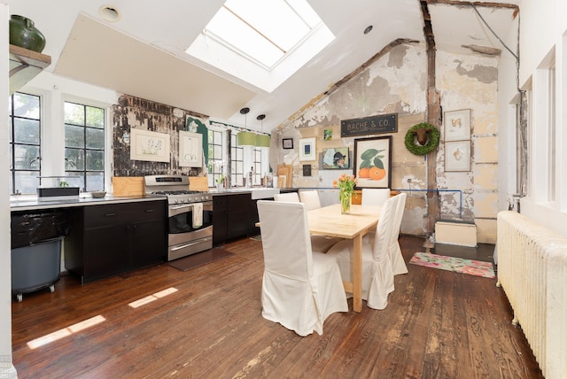 kitchen with stainless steel range with gas cooktop, a skylight, radiator, light countertops, and dark cabinetry