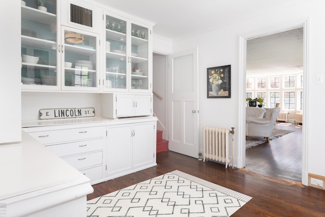 interior space featuring dark wood-type flooring, radiator, visible vents, and crown molding