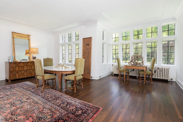 dining space with crown molding, baseboards, wood finished floors, and radiator