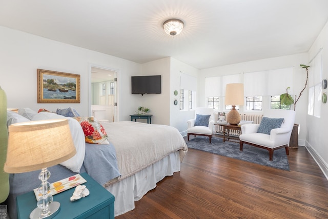 bedroom featuring ensuite bath, baseboards, and wood finished floors