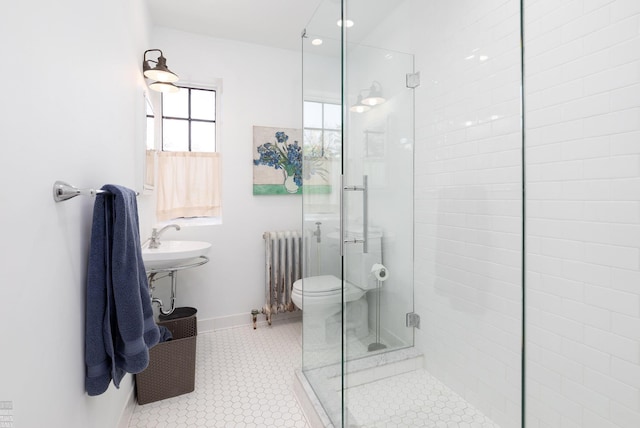 full bath with toilet, baseboards, tile patterned floors, radiator, and a stall shower