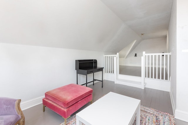 living area with lofted ceiling, baseboards, and wood finished floors