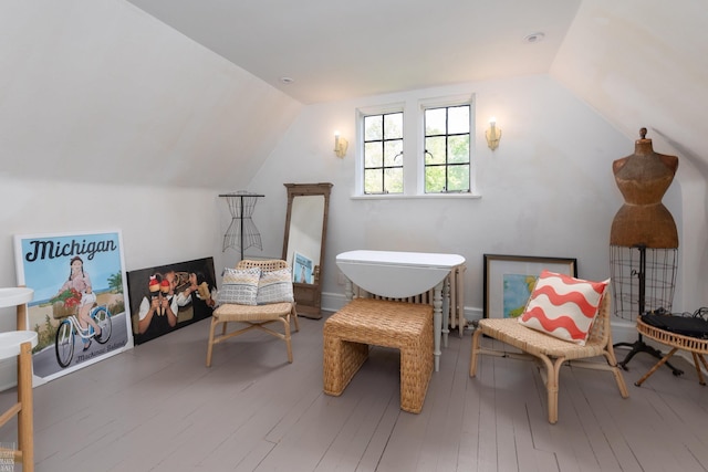 sitting room with hardwood / wood-style flooring and vaulted ceiling