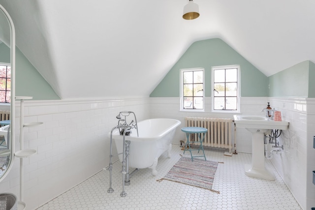 full bathroom with lofted ceiling, radiator, a wainscoted wall, and a freestanding tub