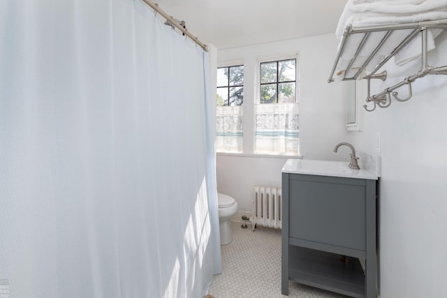 bathroom with vanity, toilet, and radiator