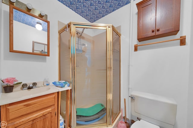 bathroom with vanity, toilet, and a shower with door