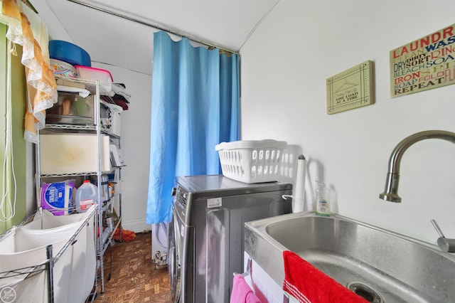 clothes washing area with washer / dryer, dark parquet floors, and sink