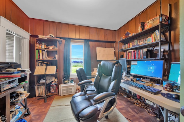 office space featuring parquet flooring, crown molding, and wooden walls