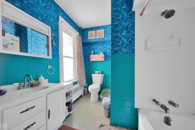 full bathroom with radiator heating unit, shower / washtub combination, toilet, and tile walls