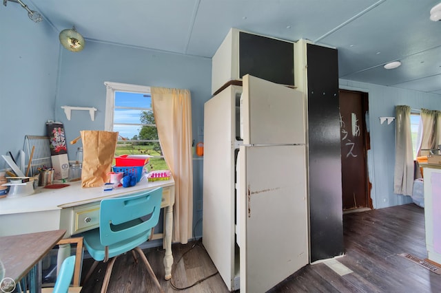 kitchen featuring plenty of natural light, dark wood-type flooring, and white refrigerator