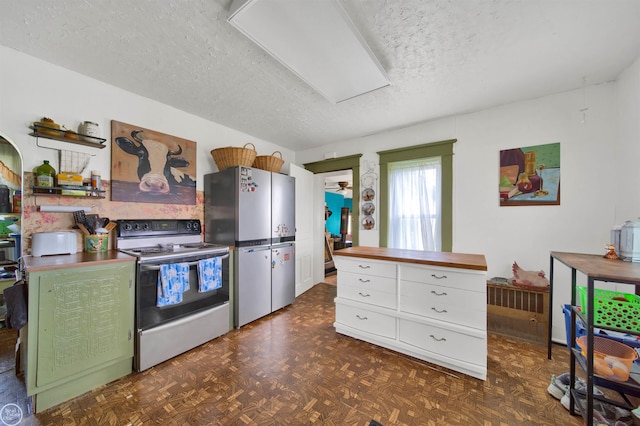 kitchen featuring a textured ceiling, white cabinets, white electric range, stainless steel refrigerator, and butcher block counters