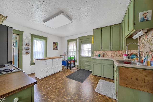 kitchen with a wealth of natural light, green cabinetry, and sink