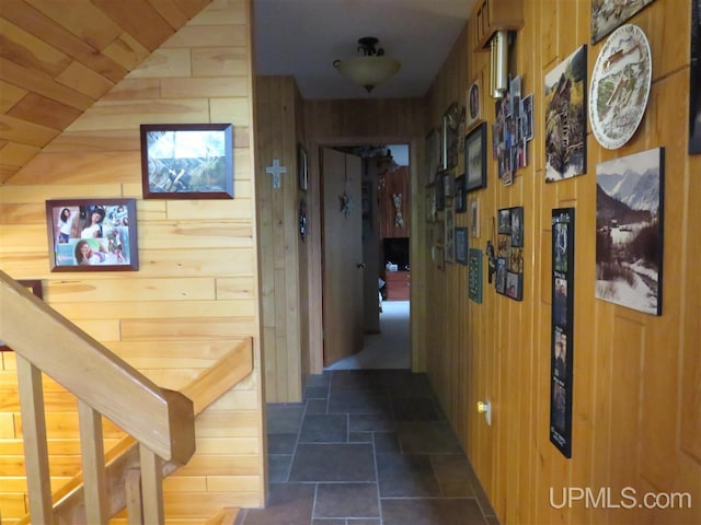 hallway featuring wood walls