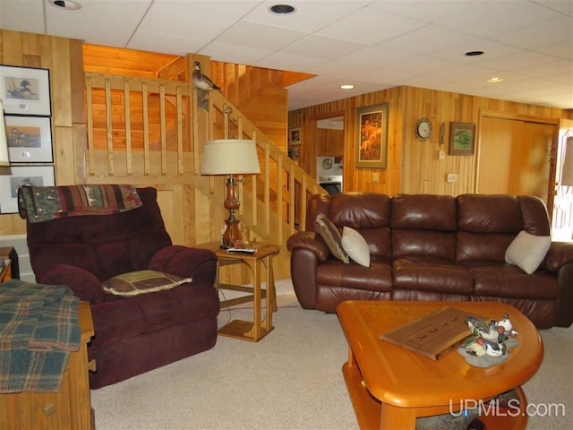 living room featuring carpet floors, wooden walls, stairway, and recessed lighting