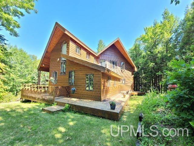 back of house with a lawn and a deck