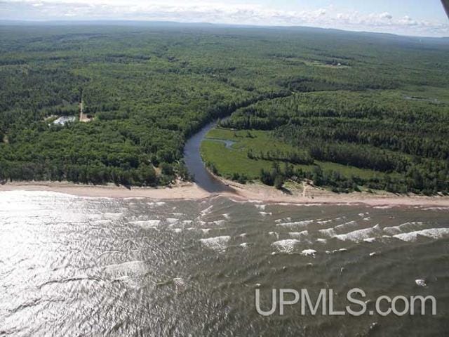 drone / aerial view featuring a wooded view