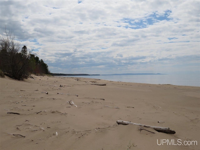 exterior space featuring a water view and a beach view