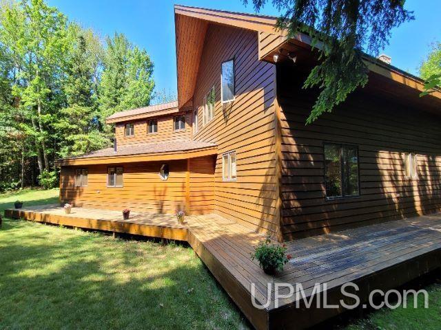 back of house with a lawn and a deck