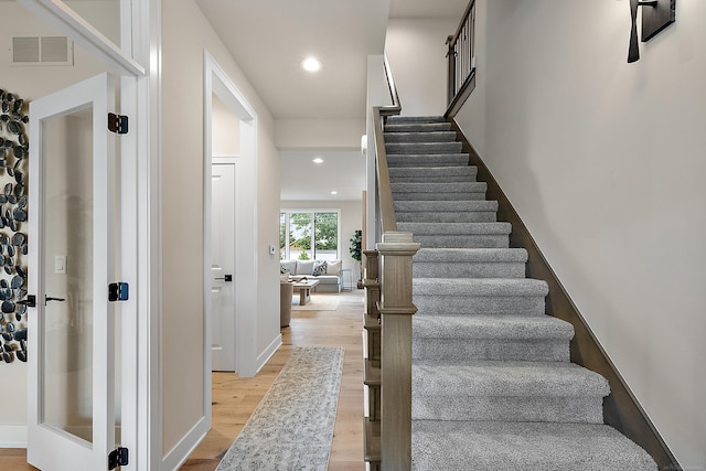 staircase with hardwood / wood-style flooring