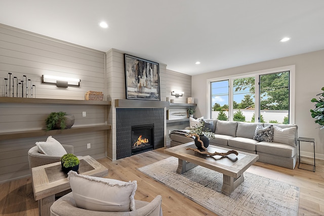 living room featuring light hardwood / wood-style flooring and wood walls