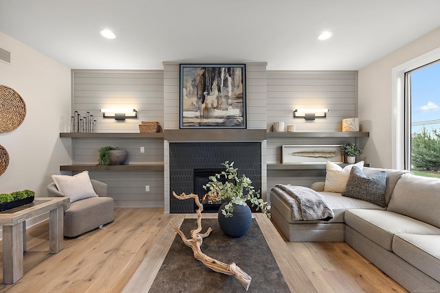 living room featuring light wood-type flooring and a fireplace