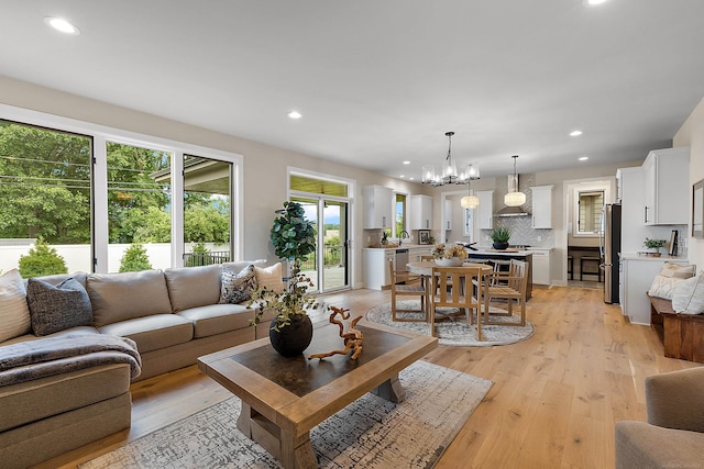 living room with light wood-type flooring and an inviting chandelier