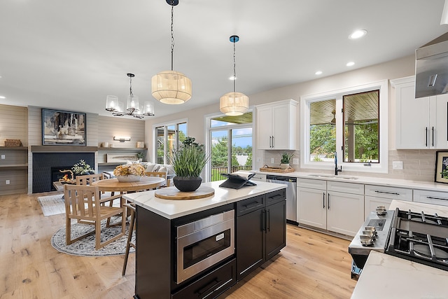 kitchen featuring sink, white cabinets, a kitchen island, and appliances with stainless steel finishes