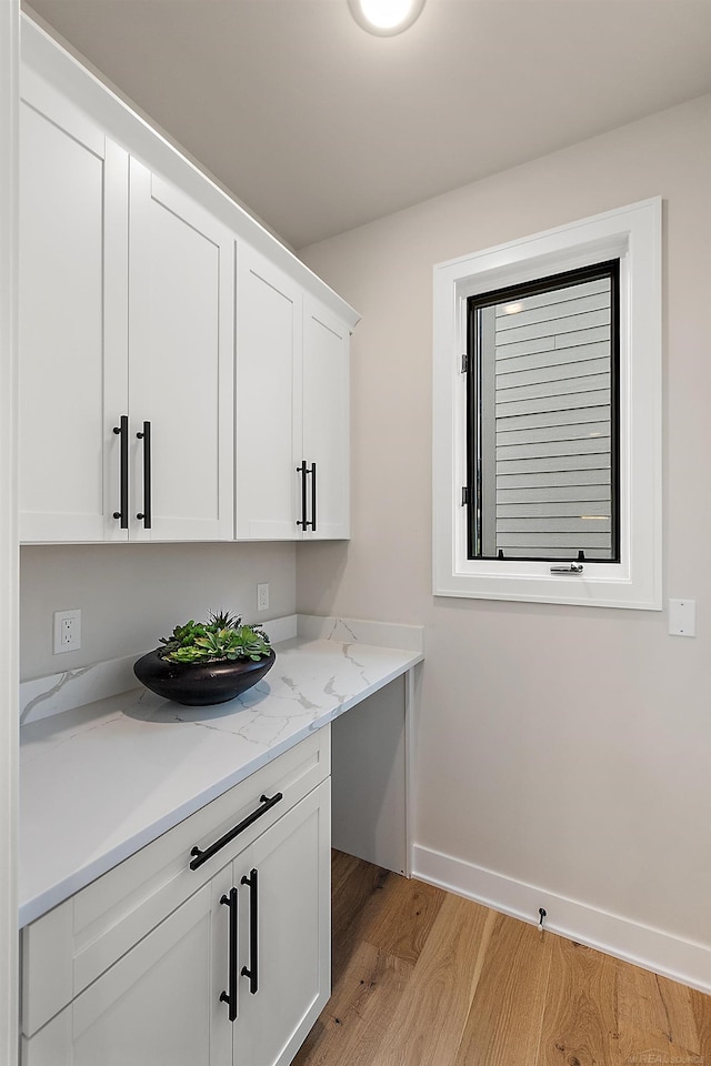 clothes washing area with light hardwood / wood-style floors