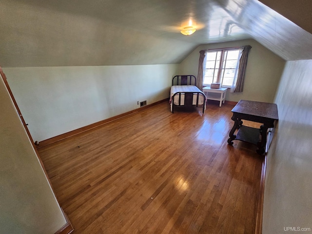 bedroom with dark wood-type flooring and lofted ceiling