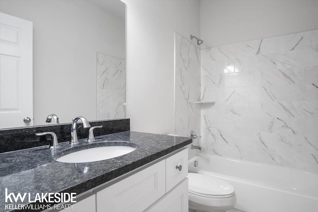 full bathroom with tiled shower / bath, vanity, and toilet