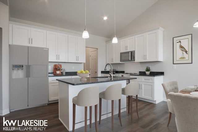 kitchen with sink, an island with sink, white cabinets, and refrigerator with ice dispenser