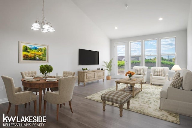 living room with an inviting chandelier, wood-type flooring, and high vaulted ceiling